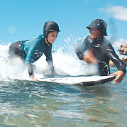 Surf instructor helps with the take off