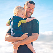 Mum is surfing, dad is watching the child